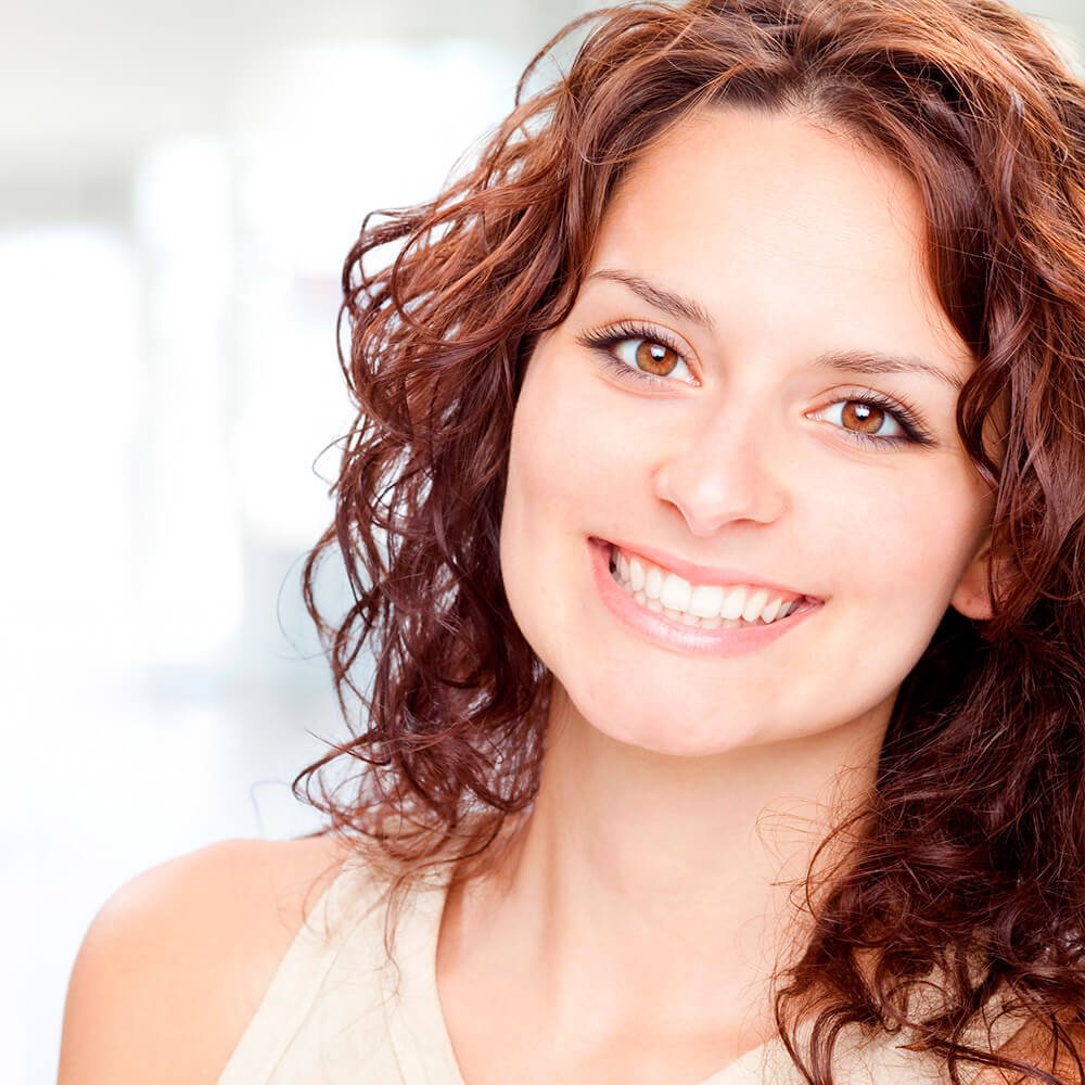 Smiling young woman with curly red hair