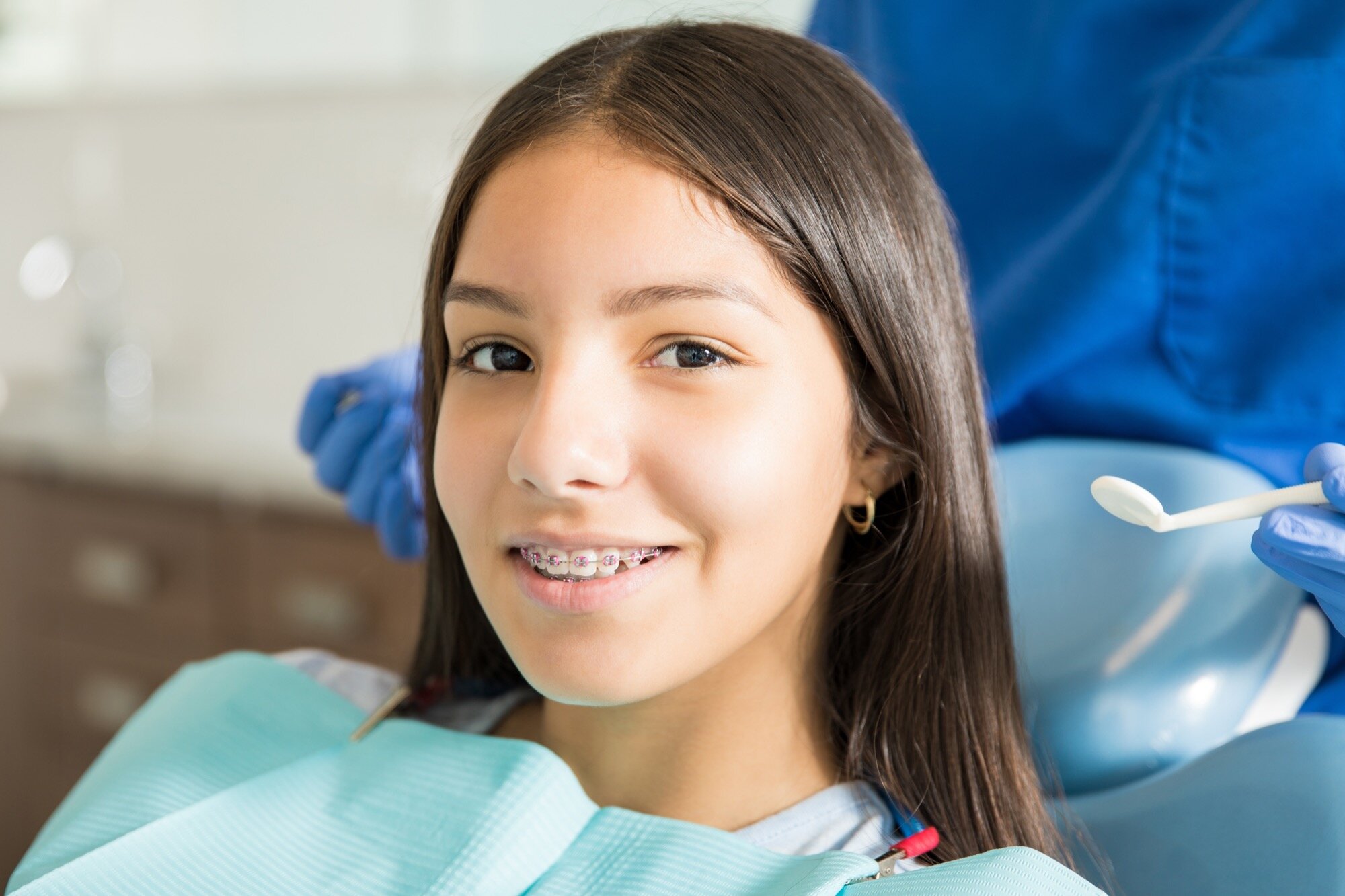 Smiling teenage girl with braces during an orthodontic check-up